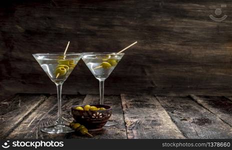 Martini with olives. On a wooden background.. Martini with olives.