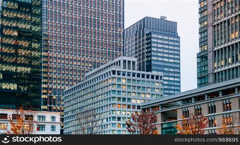Marunouchi District modern office buildings Tokyo downtown cityscape in evening with offices light on. Japan