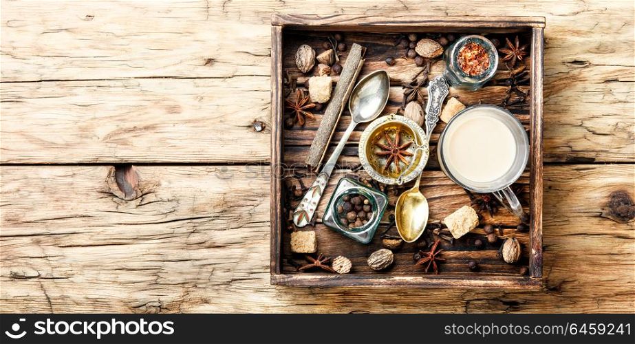 Masala tea with spices. Cup of indian masala tea and spices in a wooden tray.Masala chai
