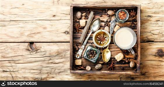 Masala tea with spices. Cup of indian masala tea and spices in a wooden tray.Masala chai