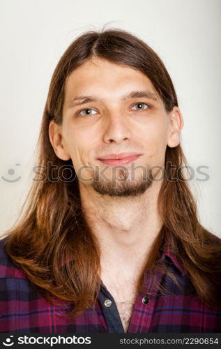 Masculinity concept. Smiling guy with long hairs. Young man in plaid shirt.. Smiling guy with long hairs.