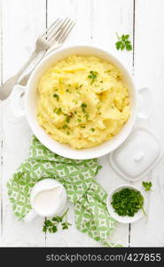 Mashed potato with butter and milk on table