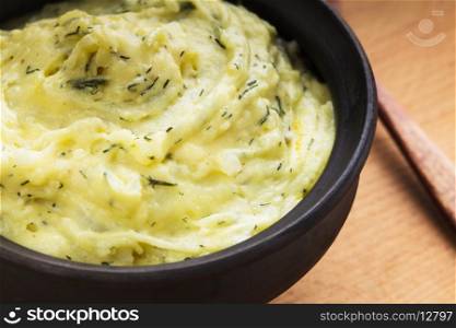 Mashed potato with dill in organic clay bowl