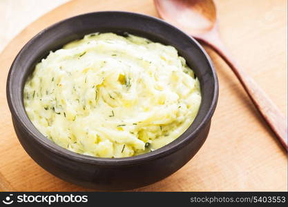 Mashed potato with dill in organic clay bowl