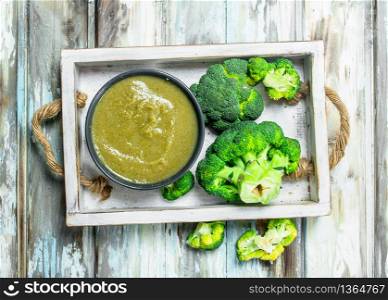 Mashed ripe broccoli in a bowl. On a wooden background.. Mashed ripe broccoli in a bowl.