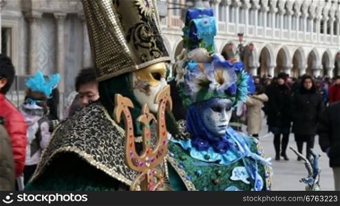 Maskierte Menschen und Touristen, auf dem Markusplatz, in Venedig.