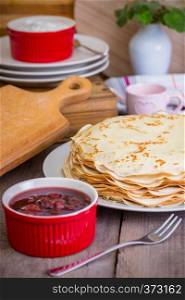 Maslenitsa and pancake week. dish full of russian tradition pancakes with sour cream at saucer