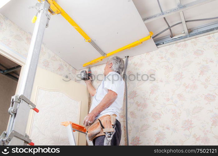 Mason drilling into a ceiling