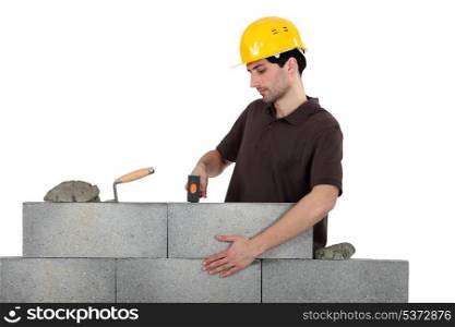 Mason knocking bricks into place with hammer