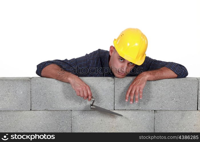 mason leaning on a stone wall