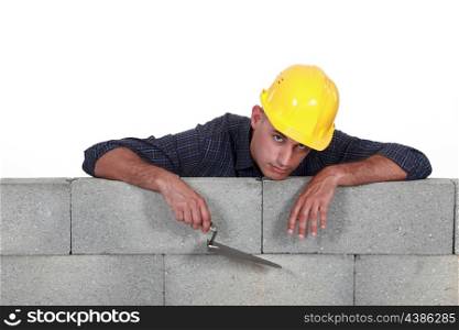 mason leaning on a stone wall