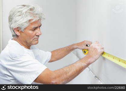 Mason measuring a white wall