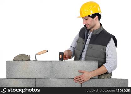 Mason mounting a brick wall