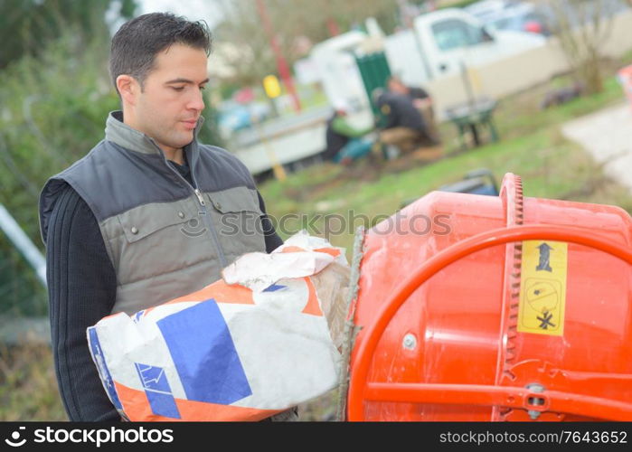 mason pouring cement to the mixer