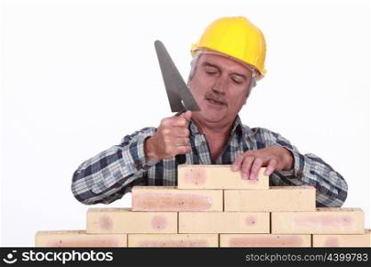 Mason tapping brick into place