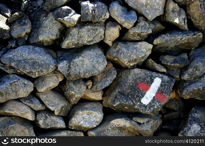 Masonry stone wall with a hike signal painted