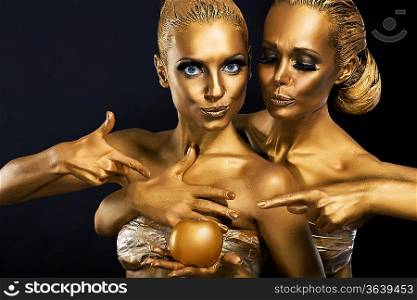 Masquerade. Enjoyment. Two Glossy Women with Golden Body Art. Glamor