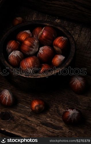 mass forest hazelnut. hazelnut in wooden bowl on a retro background