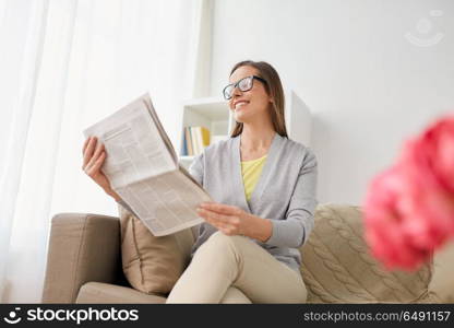 mass media and people concept - happy middle-aged woman reading newspaper at home. happy woman reading newspaper at home. happy woman reading newspaper at home