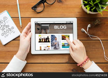 mass media, internet, technology, people and advertisement concept - close up of woman with blog web page on tablet pc computer screen on wooden table