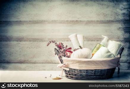 Massage and sauna setting with herbal compress balls , fresh herbs and cosmetic products on wooden background, front view. Healthy Lifestyle or Spa and wellness concept