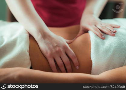 Massage salon, woman having a stomach massage.