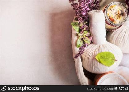 Massage setting with herbal compress balls ,fresh herbs and flowers and bathroom salts on light background,top view. Healthy Lifestyle or Spa and wellness concept