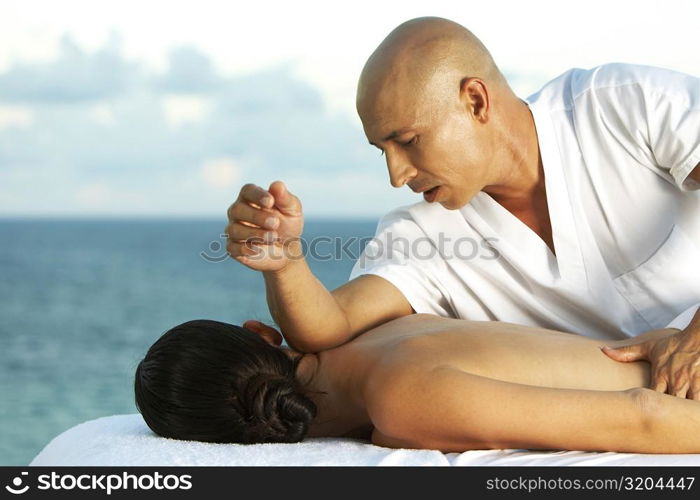 Massage therapist massaging a woman&acute;s back
