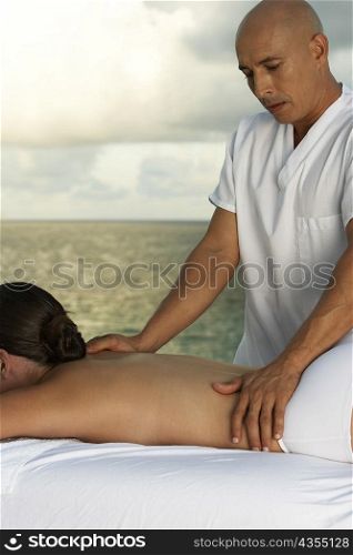 Massage therapist massaging a woman&acute;s back