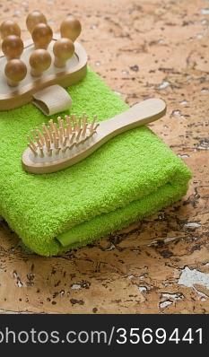 massager and hairbrush on green towel