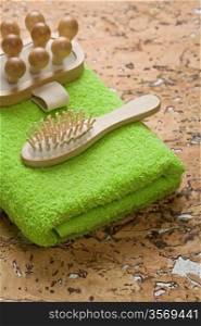 massager and hairbrush on green towel