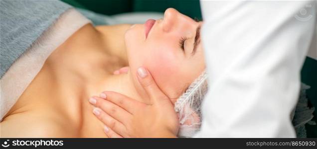 Massaging female neck. Young caucasian woman receiving neck massage relaxing in spa salon. Massaging female neck. Young caucasian woman receiving neck massage relaxing in spa salon.