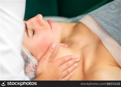 Massaging female neck. Young caucasian woman receiving neck massage relaxing in spa salon. Massaging female neck. Young caucasian woman receiving neck massage relaxing in spa salon.