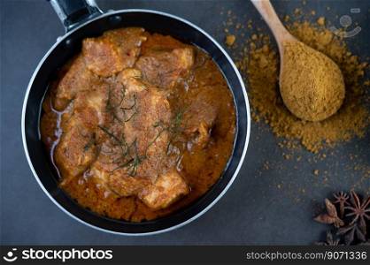 Massaman curry in a frying pan with spices on the cement floor. Selective focus