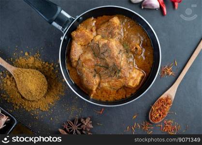 Massaman curry in a frying pan with spices on the cement floor. Selective focus