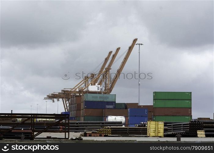 Massive crane in harbour and sea containers