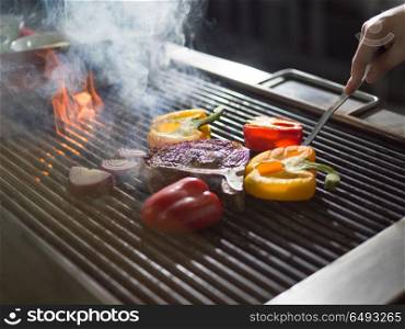 Master chef cooking delicious grilled meat steak with vegetables on a barbecue. chef cooking steak with vegetables on a barbecue
