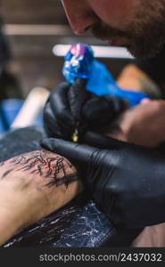 master doing tattoo arm with needle