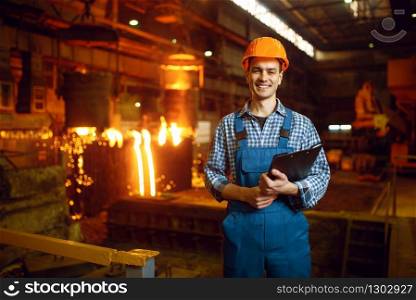 Master in helmet at furnace with liquid metal, steel factory, metallurgical or metalworking industry, industrial manufacturing of iron production on mill. Master at furnace with liquid metal, steel factory