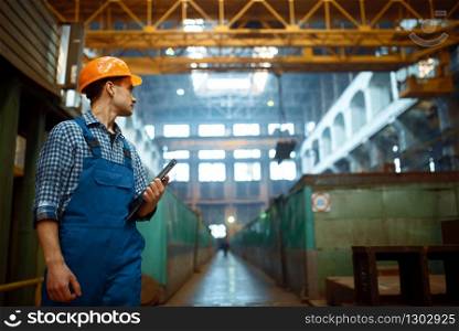 Master looks at the work of the crane operator on metal factory. Metalworking industry, industrial manufacturing of steel production. Master looks at work of crane operator on factory