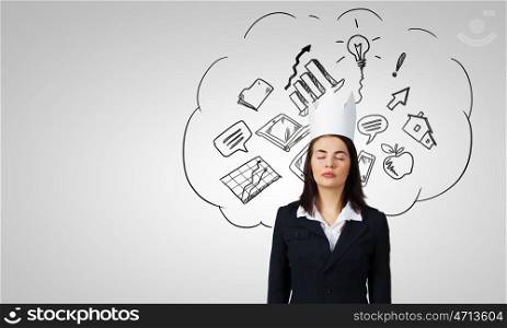 Master of creativity. Young businesswoman in paper crown and sketches at background