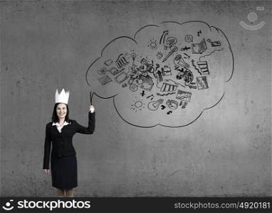 Master of creativity. Young businesswoman in paper crown and sketches at background