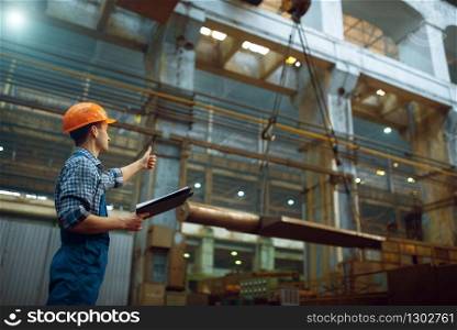 Master shows thumbs up to crane operator on metal factory. Metalworking industry, industrial manufacturing. Master shows thumbs up to crane operator, factory