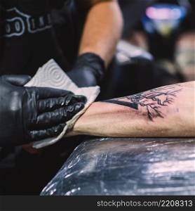 master wiping tattoo arm