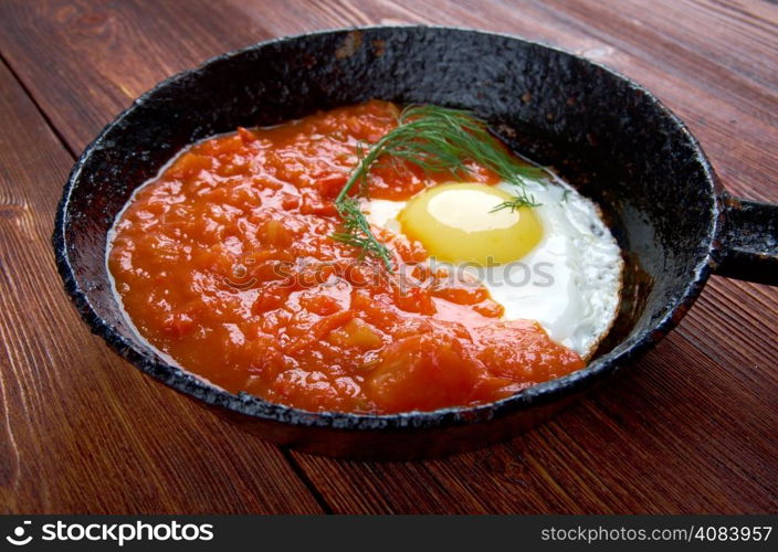 Matbucha and scrambled eggs cooked dish of tomatoes and roasted bell peppers with garlic and chili pepper. popular across the Maghreb