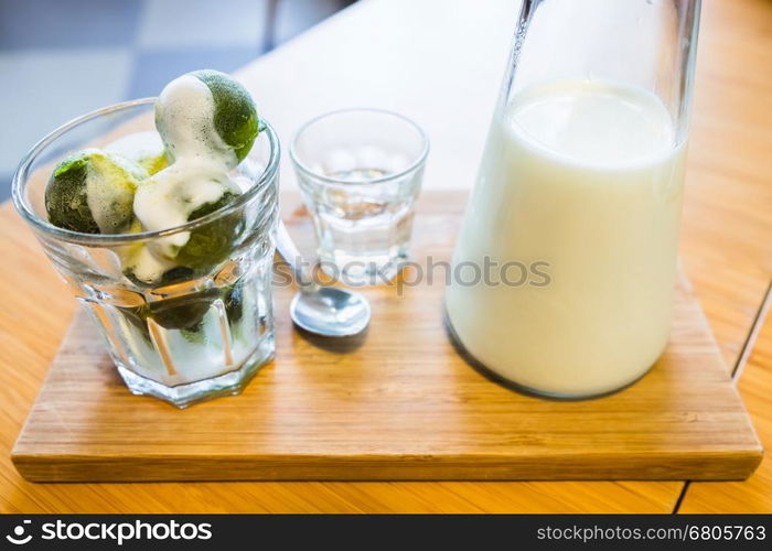 matcha ice cream and fresh milk in glass on wooden table