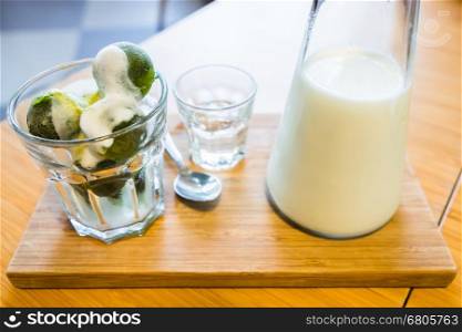 matcha ice cream and fresh milk in glass on wooden table