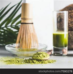 Matcha in wooden spoon with whisk and healthy green espresso