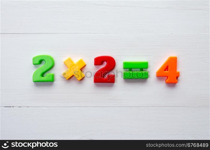 Math example with color numbers on a white wood background