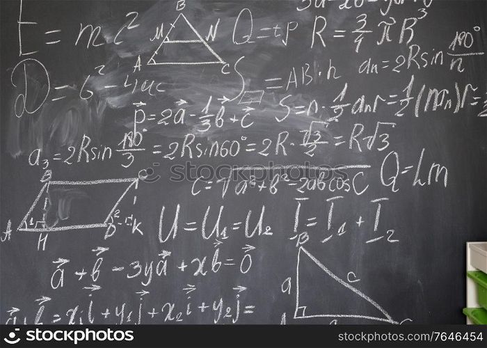 math formulas in white chalk on black board. math formulas on black board